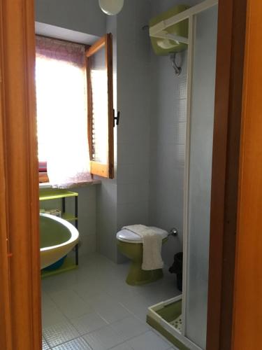 ein Bad mit einem Waschbecken, einem WC und einem Fenster in der Unterkunft Appartamenti Santa Margherita in Vieste
