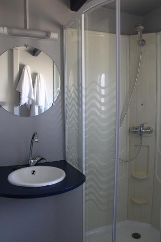 a bathroom with a sink and a shower with a mirror at Torreira Camping & Bungalows in Torreira