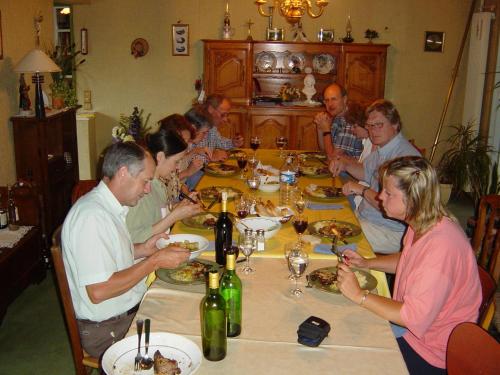 Un groupe de personnes assises autour d'une table à manger dans l'établissement Le Moulin de Fillièvres, à Fillièvres