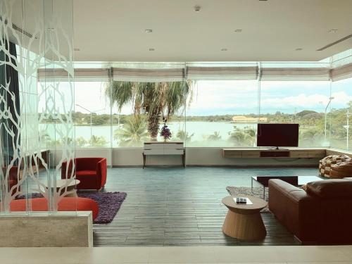 a living room with a couch and a tv at The Beverly Hills Hotel in Nakhon Ratchasima