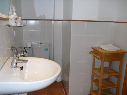 a white bathroom with a sink and a toilet at Ronda in Ronda