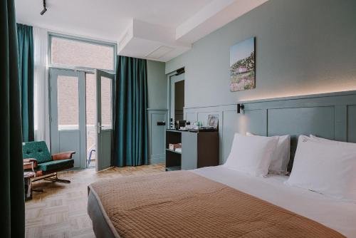 Supernova Hotel في روتردام: غرفة نوم بسرير وكرسي ونوافذ