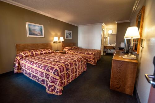 a hotel room with two beds and a television at National 9 Inn in Buttonwillow