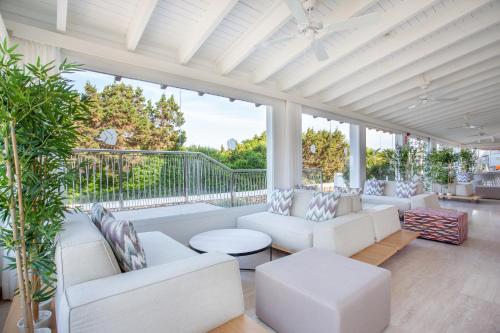 a living room with white furniture and large windows at Grupotel Aldea Cala'n Bosch in Cala'n Bosch