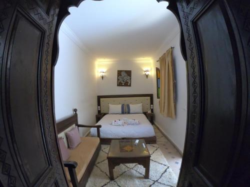 - une chambre avec un lit, un canapé et un miroir dans l'établissement Les Rêves De Marrakech, à Marrakech