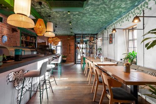 een restaurant met houten tafels en stoelen en groene plafonds bij WYNWOOD Hotel in Sint-Petersburg