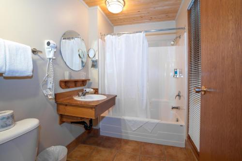 y baño con bañera, lavamanos y ducha. en La Petite Auberge de Jouvence, en Magog-Orford