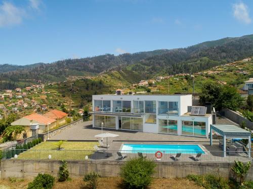 a house on a hill with a swimming pool at Villa Panoramica II in Arco da Calheta