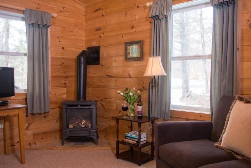 a living room with a wood paneled wall with a stove at Sterling Ridge Resort in Jeffersonville