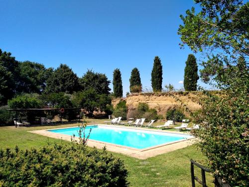 a swimming pool in a yard with chairs and trees at Locanda Rosati in Orvieto