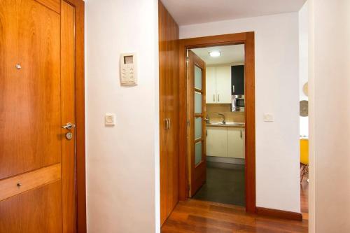 a hallway leading into a kitchen with a door at Apartamento Fórum-Ciencias con Piscina, Gym & Parking in Granada