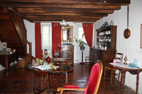 ein Wohnzimmer mit 2 Tischen und Stühlen in einem Zimmer in der Unterkunft petite maison berrichonne in Chârost