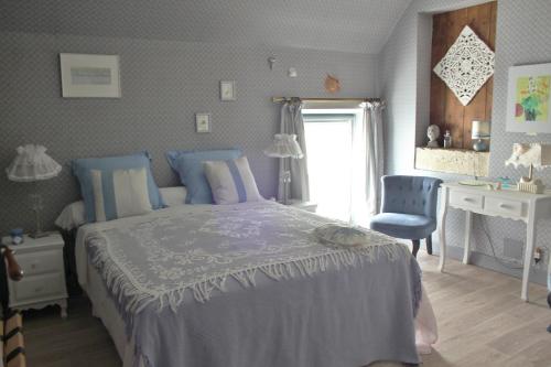 Schlafzimmer mit einem Bett, einem Schreibtisch und einem Fenster in der Unterkunft petite maison berrichonne in Chârost