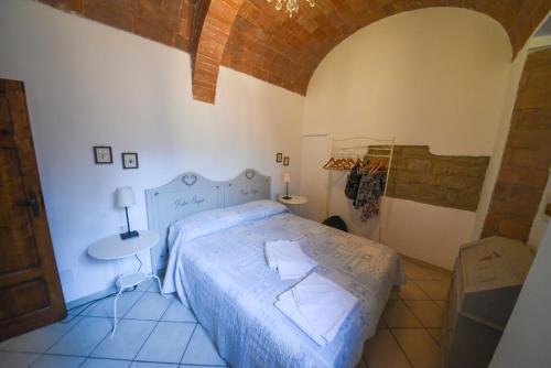 a bedroom with a bed and a table in it at Il Sogno di Annalisa in Famiglia in Volterra
