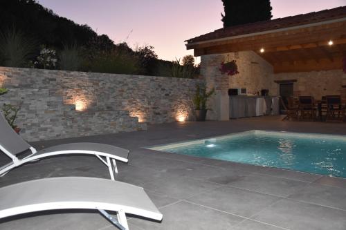 a swimming pool in a yard with a chair and a house at Domaine de calbiac in Dolmayrac
