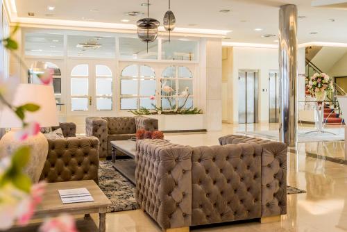 a salon with brown leather chairs and a table at Eurostars Louxo Talaso in Isla de la Toja