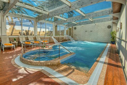 una grande piscina coperta con soffitto in vetro di Hotel Talaso Louxo La Toja a Isla de la Toja