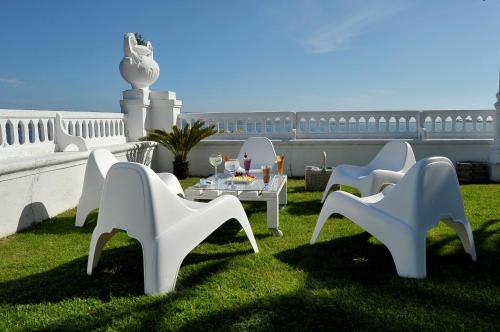 a group of white chairs and a table on the grass at Eurostars Louxo Talaso in Isla de la Toja