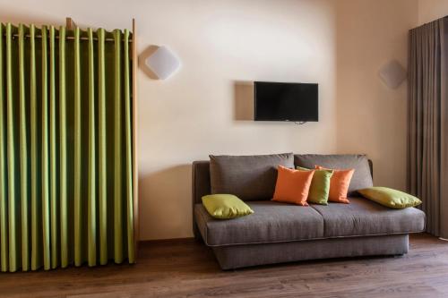 a living room with a couch with a green curtain at Almstüble Bergfrieden in Damuls