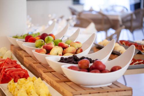 a buffet with many bowls of fruit on a table at Grupotel Aldea Cala'n Bosch in Cala'n Bosch