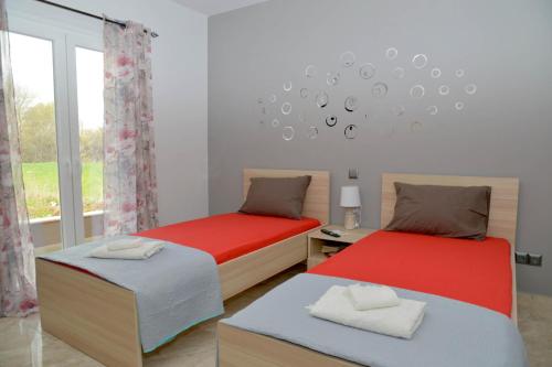 a bedroom with two beds and a window at ANTIGONH COUNTRYSIDE VILLA !i in Kokkínion