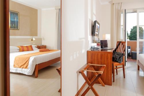 a bedroom with a bed and a desk in a room at Hotel Michelangelo in Terranuova Bracciolini