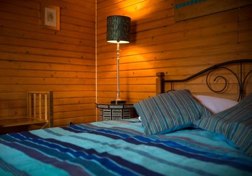 a bedroom with a bed with a lamp in it at Rakši in Cēsis