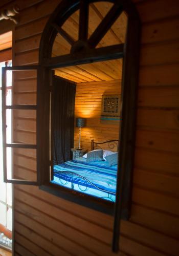 a view of a bed in a room through a mirror at Rakši in Cēsis