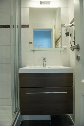 a bathroom with a sink and a mirror and a shower at Bootshaus Appartements in Cuxhaven