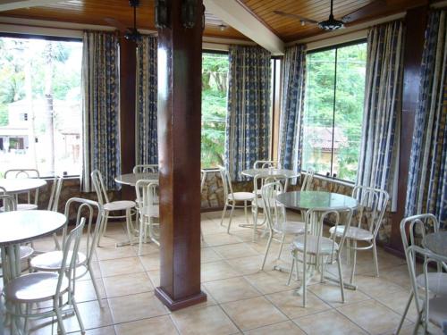 a room with tables and chairs and windows at Pousada Praia D'Azul in Abraão