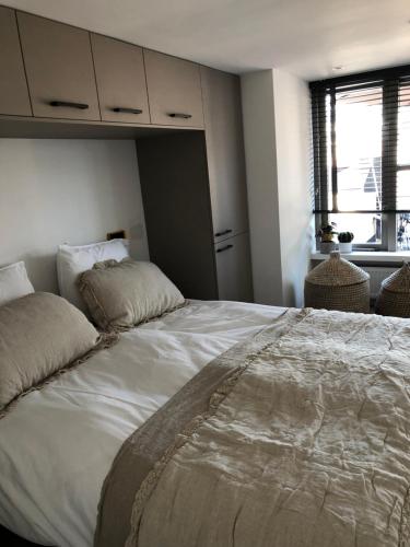 1 cama blanca grande en una habitación con ventana en Bergenshofje en Bergen