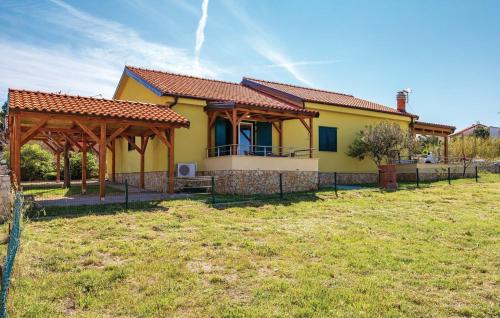 a yellow house with a gazebo in a field at Apartments Duplic in Povljana