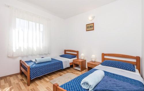 um quarto com 2 camas e uma janela em Apartments Duplic em Povljana