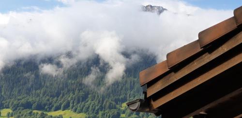 a view of a mountain in the clouds from a bench at Ferienhaus & Ferienwohnung Wiñay Wayna Gotschna Blick Klosters in Klosters Serneus