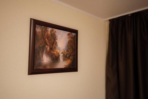 a picture of a painting hanging on a wall at Boglárka Apartmanház in Mezőkövesd