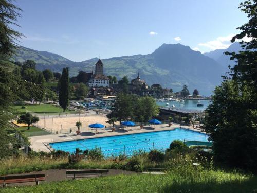 a large swimming pool with a town and a lake at Ferienwohnung Ankerplatz in Spiez