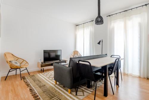 a dining room with a table and chairs and a tv at Sta Catarina - Cascais Beach Apartments in Cascais