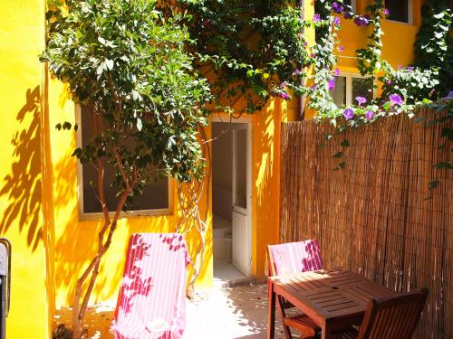een tafel en stoelen voor een geel huis bij La maison jaune in Sète