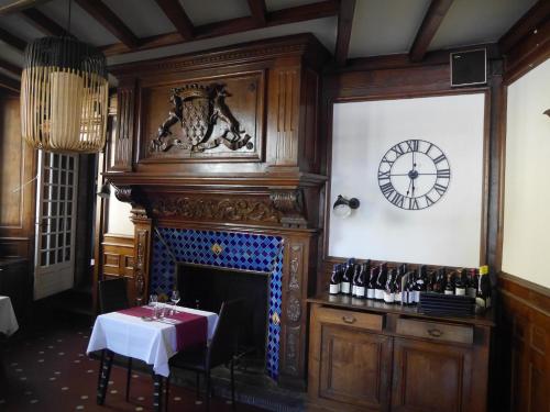 クインティンにあるLogis Hôtel du Commerceの暖炉付きの部屋(壁に時計付)