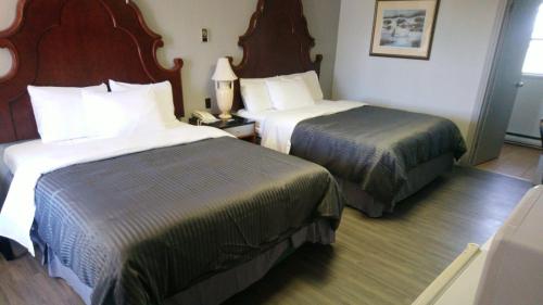 a hotel room with two beds and a telephone at Port Motel in Port Colborne