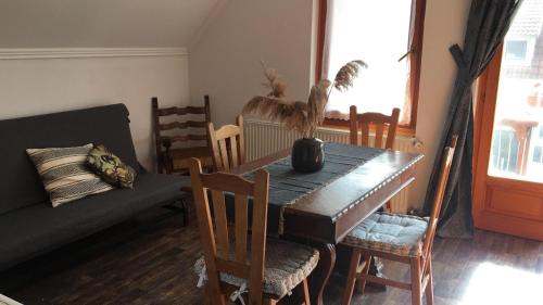 a dining room with a table and chairs and a couch at Sipos Borház és Vendégház in Badacsonyörs