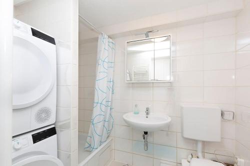 een witte badkamer met een wastafel en een spiegel bij FeWo Sommerhalde in Althütte
