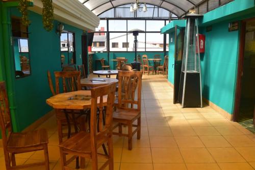 an empty restaurant with wooden tables and chairs at Bolivian Heights Hostel in La Paz