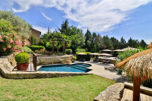 a swimming pool in a yard with a patio at Le Mas de la Lombarde in Lourmarin