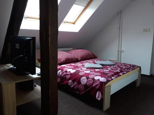 a bedroom with a bed with a purple comforter at Penzion Vulture Havířov in Havířov