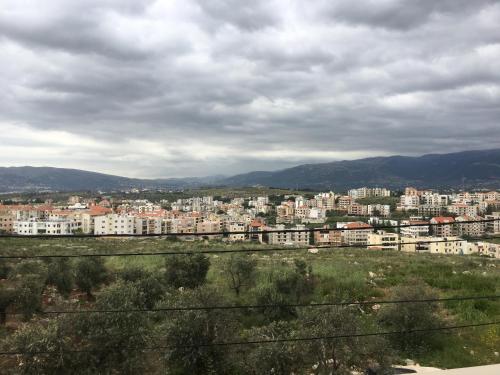 uma vista para uma cidade com edifícios à distância em Koura Nahla Apartment em An Nakhlah