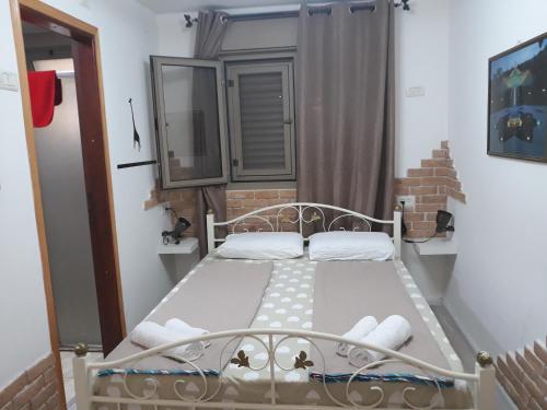 ein kleines Schlafzimmer mit einem Bett in einem Zimmer in der Unterkunft Tamer Guest house in Haifa