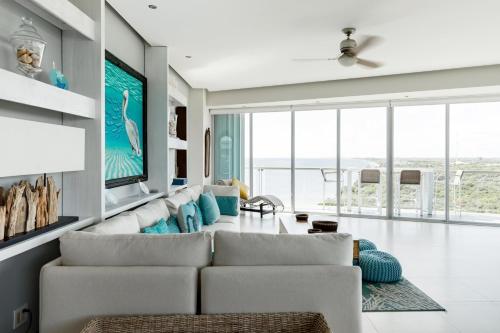 sala de estar con sofá y TV en Espectacular Departamento de lujo frente al mar, en Cancún