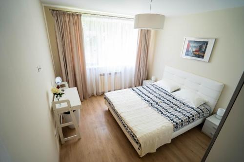 a small bedroom with a bed and a window at Cris Apartament in Suceava