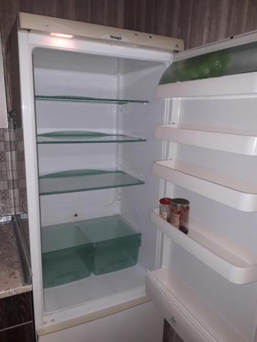 an empty refrigerator with its door open in a kitchen at Apartment 30 m2 on Sergei Esenin 11 in Kharkiv